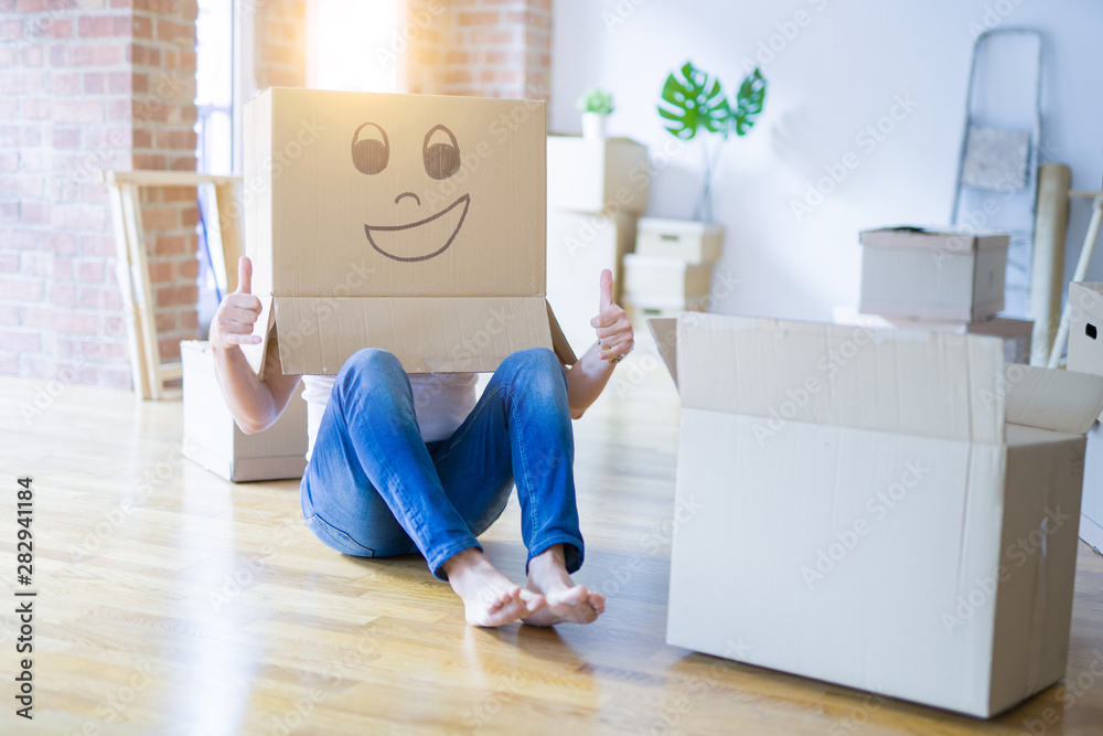 Man wearing funny cardboard box with happy face, moving to a new house, crazy and creative concept - obrazy, fototapety, plakaty 