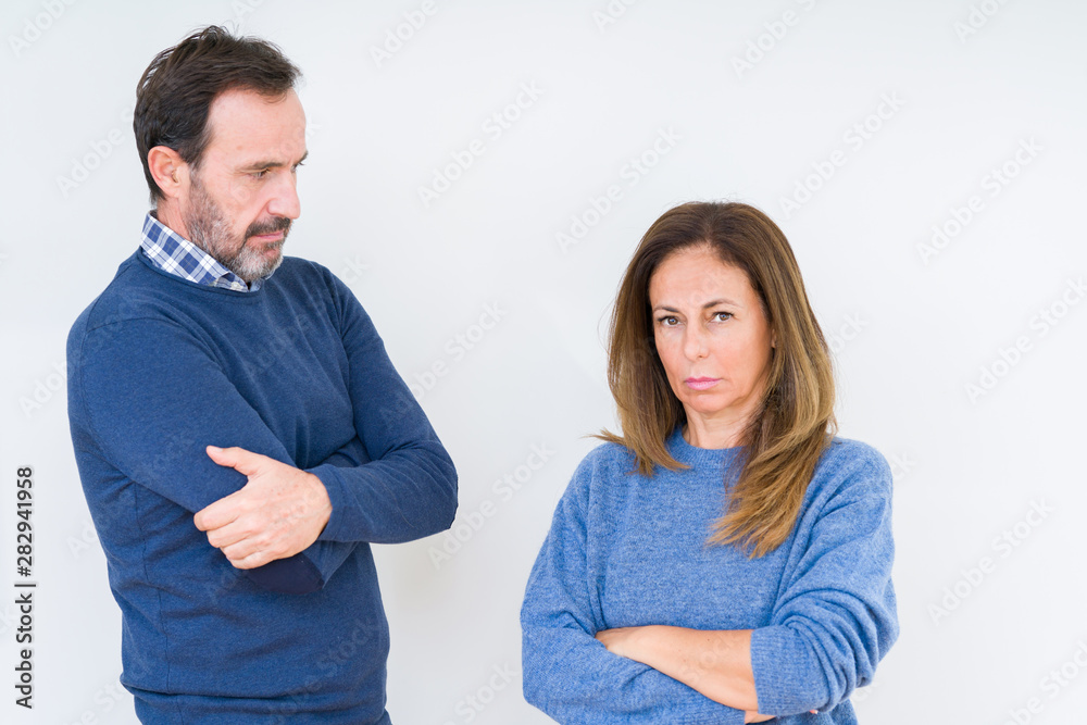 Beautiful middle age couple in love over isolated background skeptic and nervous, disapproving expression on face with crossed arms. Negative person. Beautiful middle age couple in love over isolated background skeptic and nervous, disapproving expression on face with crossed arms. Negative person.