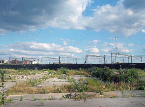 a large unused urban brownfield site with open land covered in cracked overgrown concrete awaiting development in leeds england