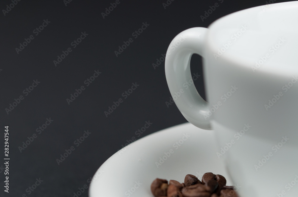 Fototapeta premium White cup of coffee and coffee beans isolated on black background
