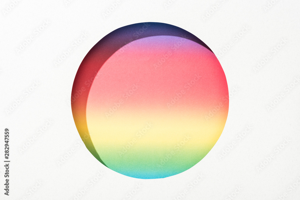 cut out round hole in white paper on colorful rainbow background
