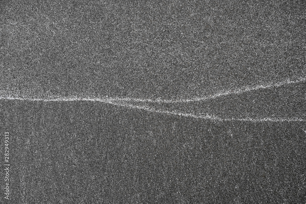Fototapeta premium Lines on sand, white patterns left by waves on the beach.