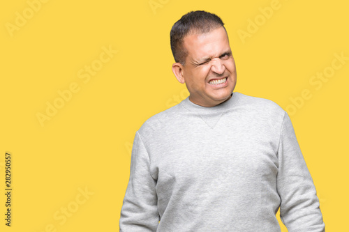 Middle age arab man wearing sport sweatshirt over isolated background winking looking at the camera with sexy expression, cheerful and happy face.