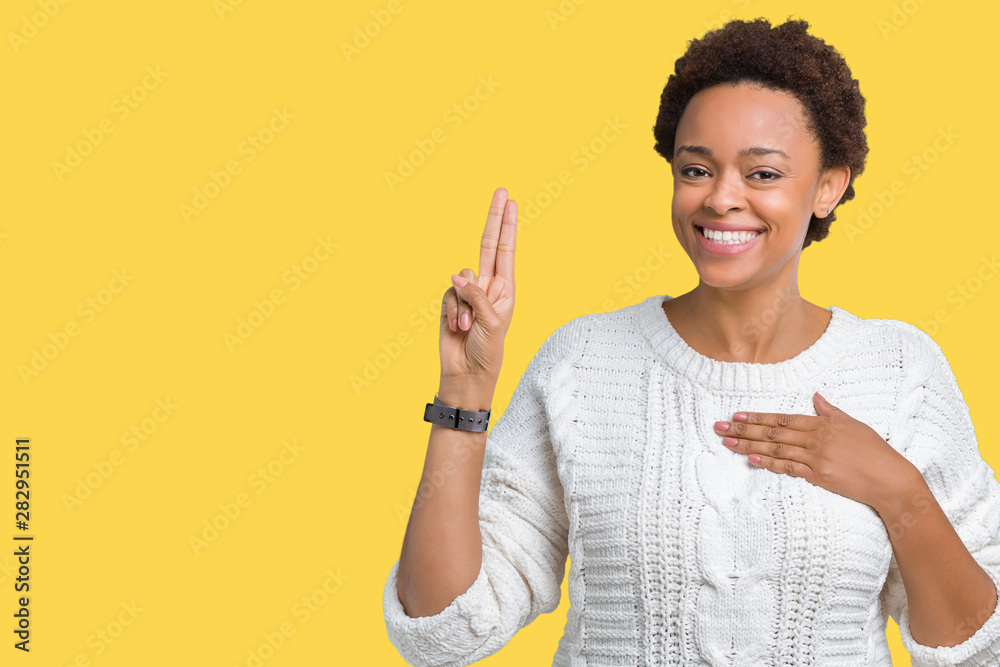 Beautiful young african american woman wearing sweater over isolated background Swearing with hand on chest and fingers, making a loyalty promise oath Beautiful young african american woman wearing sweater over isolated background Swearing with hand on chest and fingers, making a loyalty promise oath