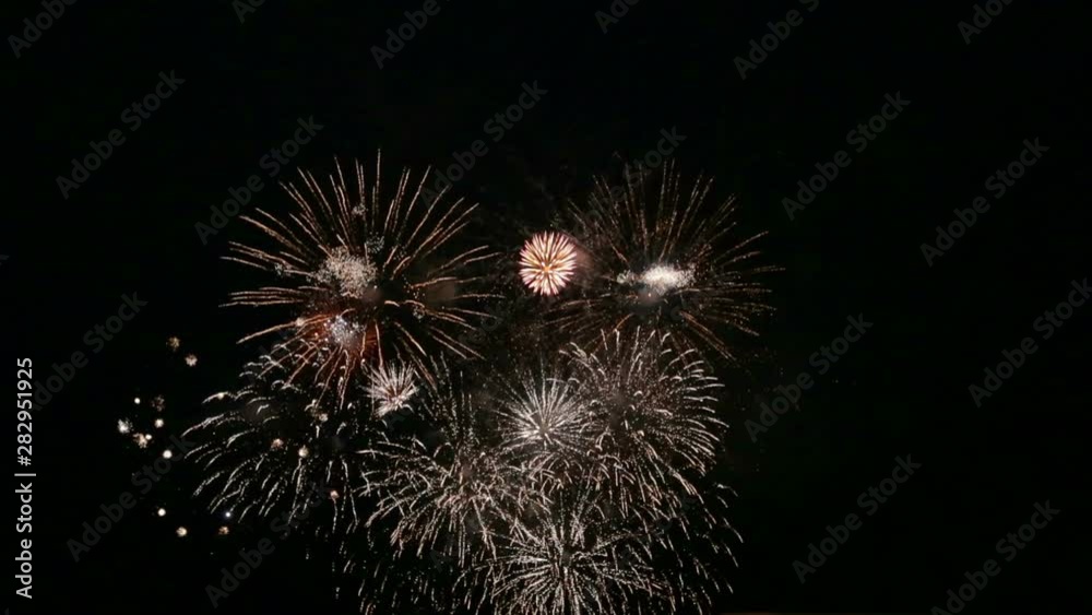 Bright balloons of festive fireworks in the night sky over the river. Time laps Bright balloons of festive fireworks in the night sky over the river. Time laps