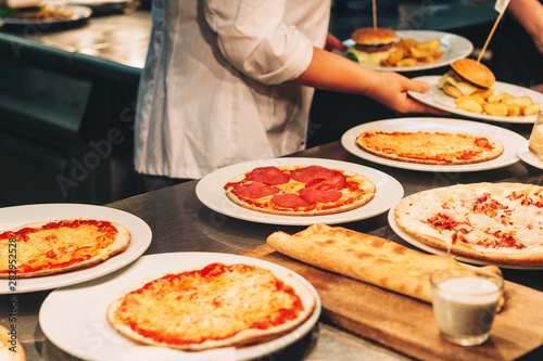 Food orders on the kitchen table in the restaurant, pizza, Flammkuchen and garlic bread