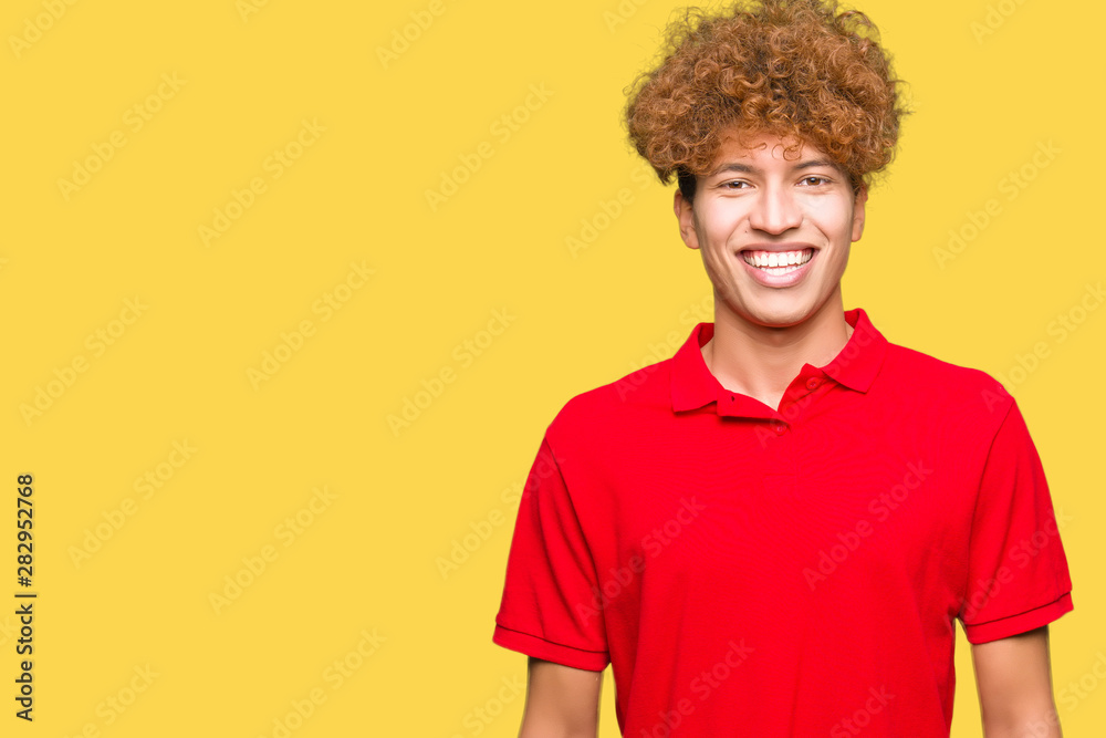 Young handsome man with afro hair wearing red t-shirt with a happy and cool smile on face. Lucky person. Young handsome man with afro hair wearing red t-shirt with a happy and cool smile on face. Lucky person.