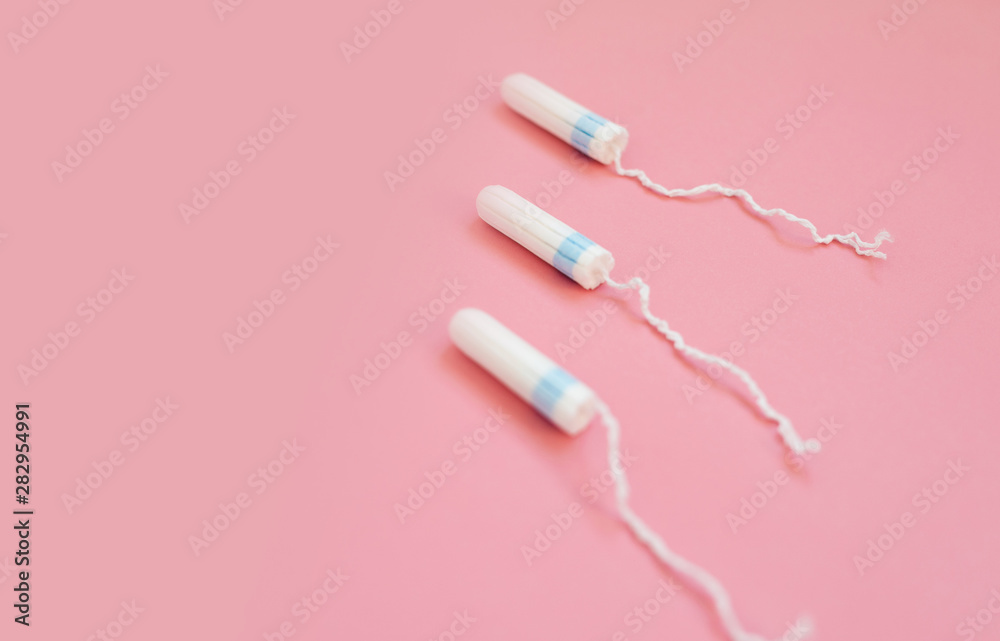 Medical female tampon on a pink background. Hygienic white tampon for women. Cotton swab Medical female tampon on a pink background. Hygienic white tampon for women. Cotton swab
