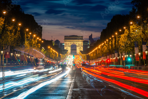 Night scence illuminations traffic street of the Impressive Arc de Triomphe Paris along the famous tree lined Avenue des Champs-Elysees in Paris, France. © ake1150