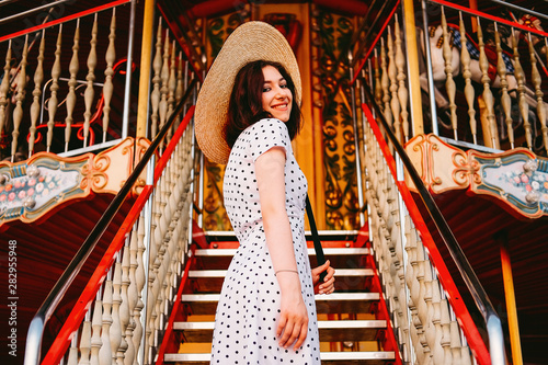 Elegant young lady standing at the staircase in amusement park