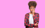 Beautiful young african american woman wearing glasses over isolated background looking stressed and nervous with hands on mouth biting nails. Anxiety problem.