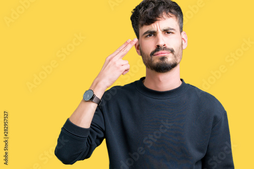 Canvas Print Young handsome man over isolated background Shooting and killing oneself pointing hand and fingers to head, suicide gesture