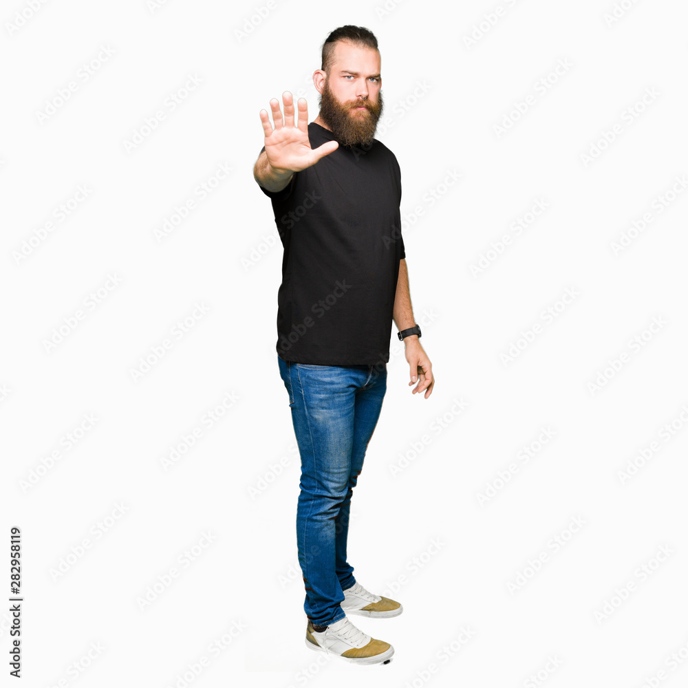 Young blond man wearing casual t-shirt doing stop sing with palm of the hand. Warning expression with negative and serious gesture on the face. Young blond man wearing casual t-shirt doing stop sing with palm of the hand. Warning expression with negative and serious gesture on the face.