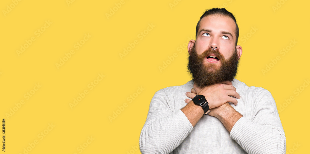 Obraz premium Young blond man wearing casual sweater shouting and suffocate because painful strangle. Health problem. Asphyxiate and suicide concept.