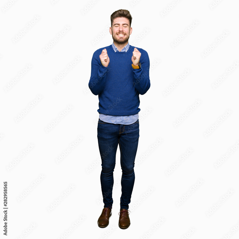 Fototapeta premium Young handsome bussines man excited for success with arms raised celebrating victory smiling. Winner concept.