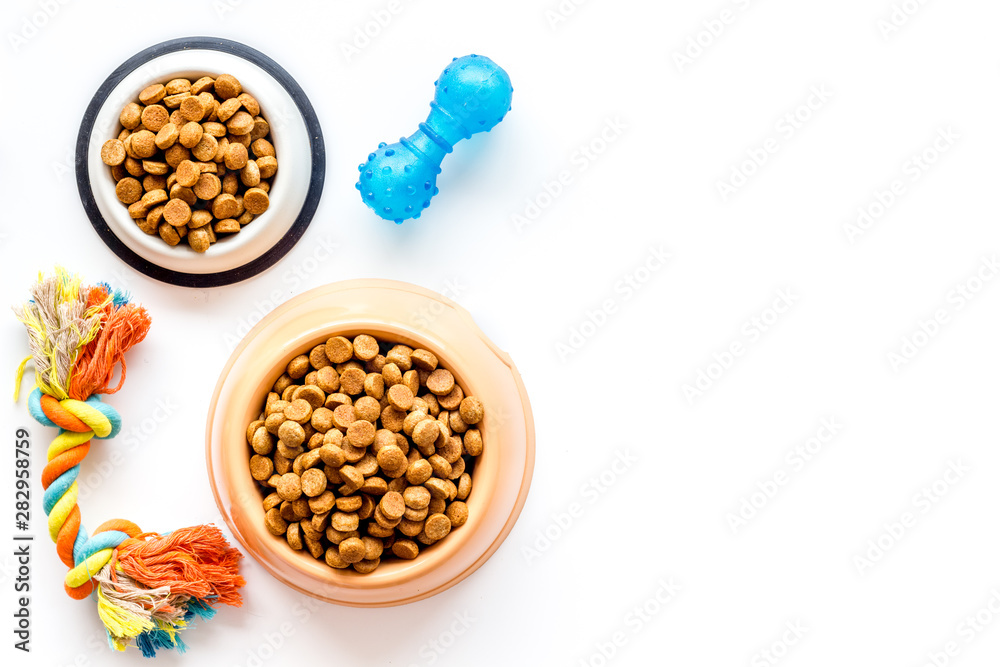 Cat and dog dry food in bowl and toys on white background top view mockup Cat and dog dry food in bowl and toys on white background top view mockup