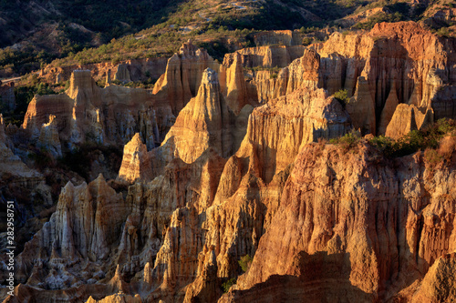 Earth Forest of Yuanmou in Yunnan Province, China - Exotic earth and sandstone formations glowing in the sunlight. Naturally formed pillars of rock and clay with unique erosion patterns. China Travel