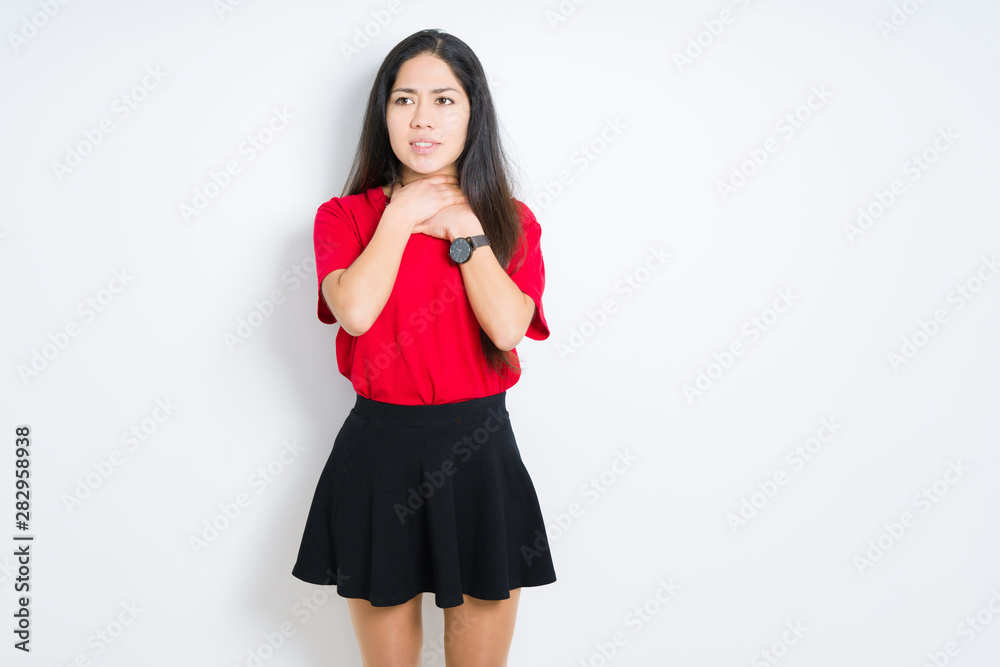 Beautiful brunette woman wearing red t-shirt and skirt over isolated background shouting and suffocate because painful strangle. Health problem. Asphyxiate and suicide concept. Beautiful brunette woman wearing red t-shirt and skirt over isolated background shouting and suffocate because painful strangle. Health problem. Asphyxiate and suicide concept.