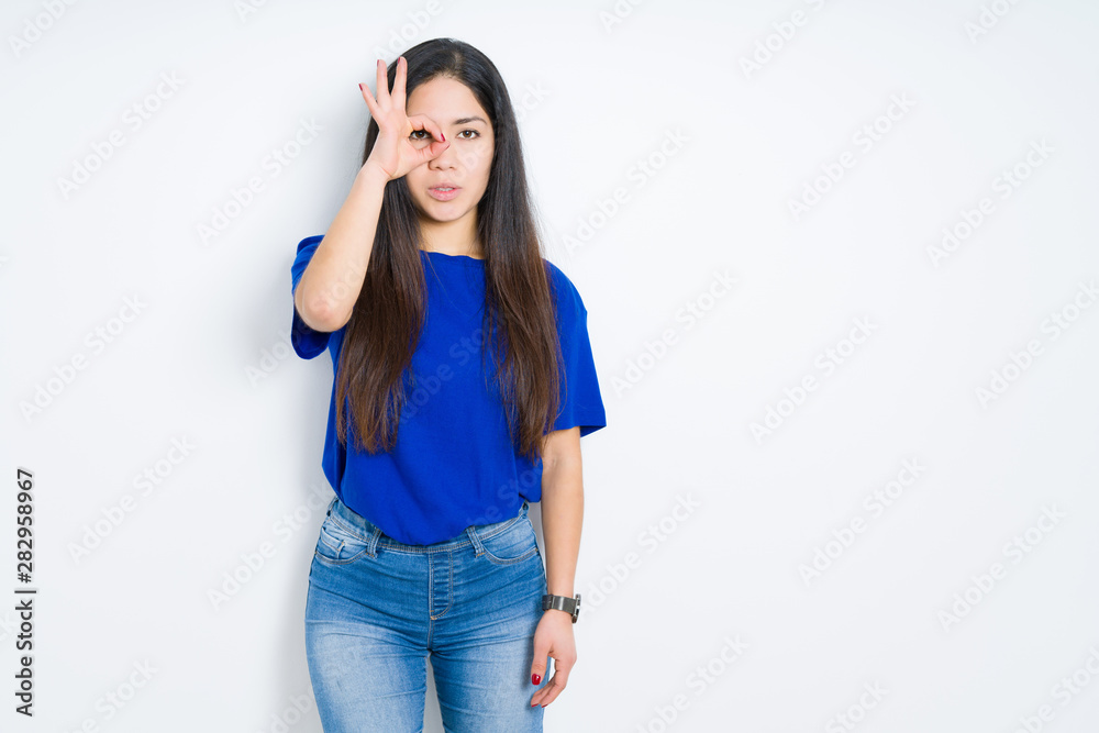 Beautiful brunette woman over isolated background doing ok gesture shocked with surprised face, eye looking through fingers. Unbelieving expression. Beautiful brunette woman over isolated background doing ok gesture shocked with surprised face, eye looking through fingers. Unbelieving expression.