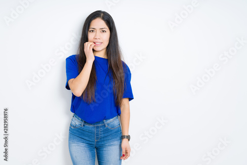 Beautiful brunette woman over isolated background looking stressed and nervous with hands on mouth biting nails. Anxiety problem.