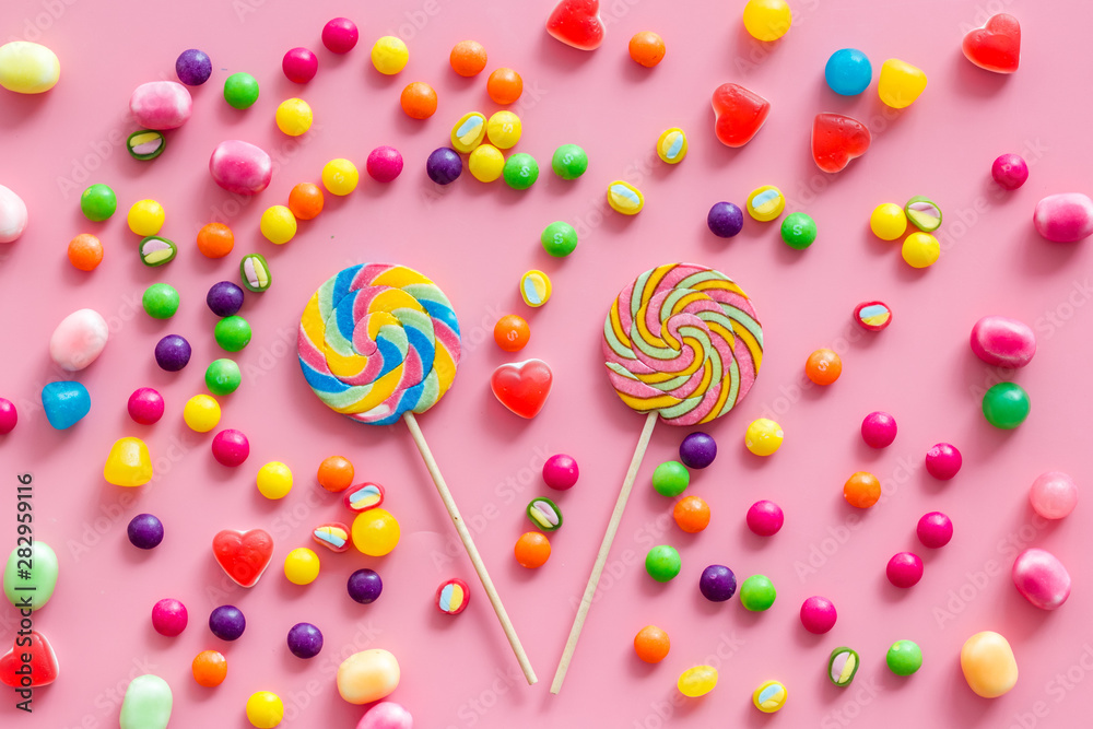 Candy dots, lollipop and fruit jelly for blog design on pink background top view pattern Candy dots, lollipop and fruit jelly for blog design on pink background top view pattern