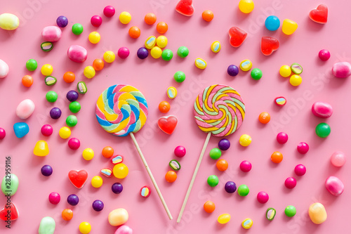 Candy dots, lollipop and fruit jelly for blog design on pink background top view pattern