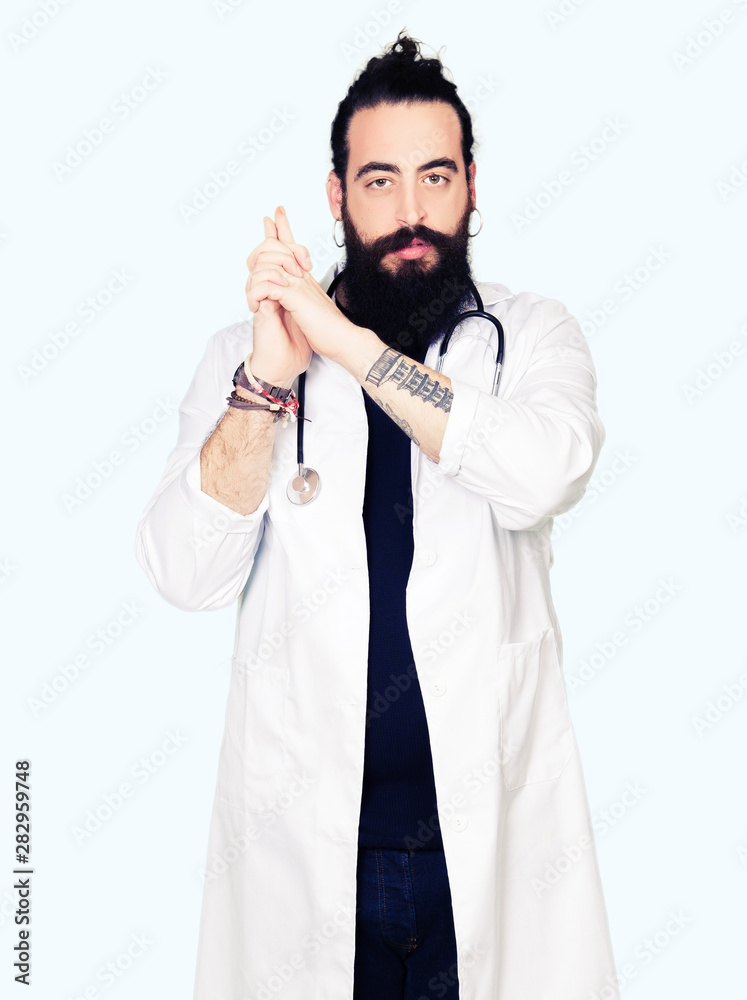 Doctor with long hair wearing medical coat and stethoscope Holding symbolic gun with hand gesture, playing killing shooting weapons, angry face