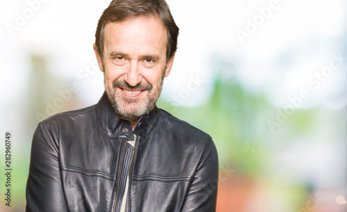 Middle age handsome man wearing black leather jacket Smiling with hands palms together receiving or giving gesture. Hold and protection © Krakenimages.com
