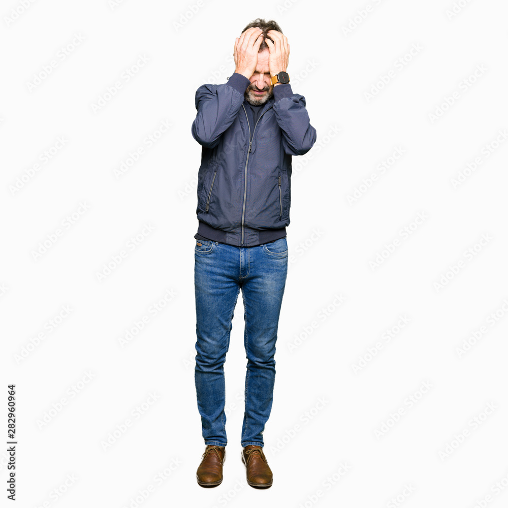 Middle age handsome man wearing a jacket suffering from headache desperate and stressed because pain and migraine. Hands on head. Middle age handsome man wearing a jacket suffering from headache desperate and stressed because pain and migraine. Hands on head.