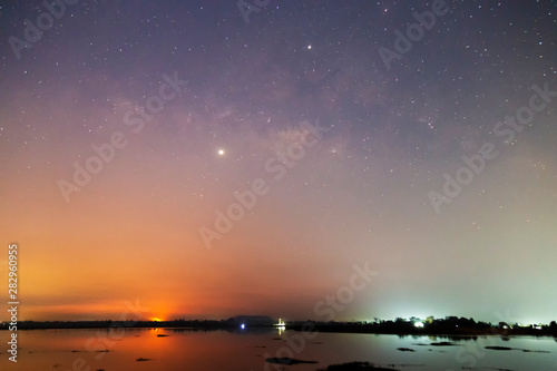 Landscape of the milky way galaxy over the river with sunrise at rural Thailand. Star light on the sky with tree at Sisaket province ,Thailand.
