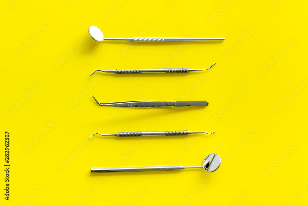 Dentist work desk with tools for teeth on yellow background top view Dentist work desk with tools for teeth on yellow background top view