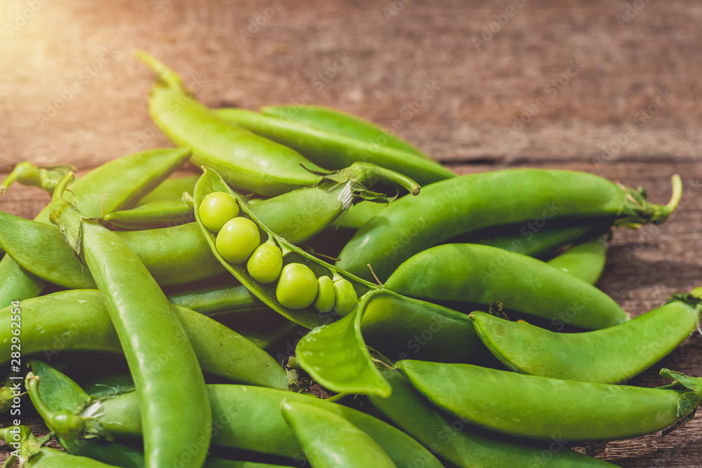 Fresh green peas or beans on wooden table Fresh green peas or beans on wooden table