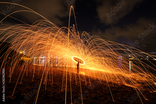 Steel wool spinning on beach with lots of sparks flying