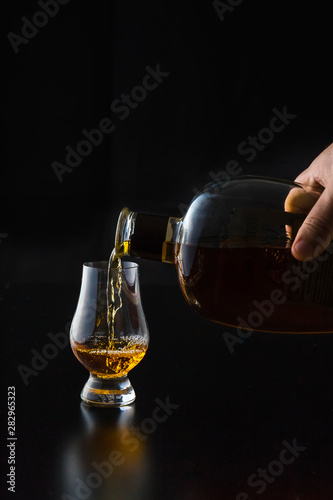 Kentucky straight bourbon whiskey being poured into a glencairn glass. photo