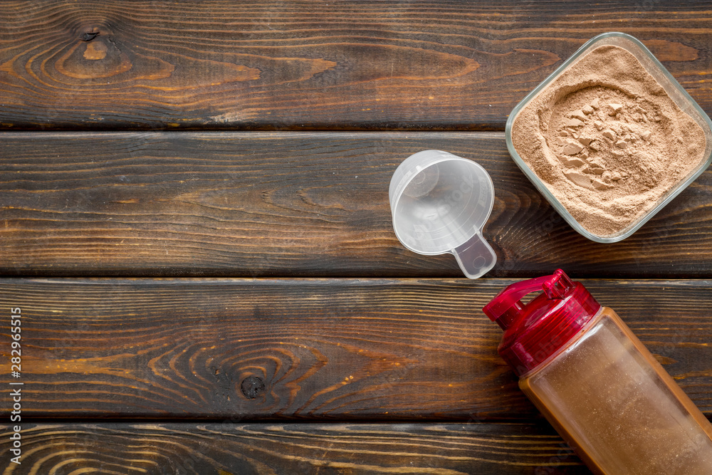 Nutrition for workout with protein cocktail powder and shaker on wooden background top view mockup Nutrition for workout with protein cocktail powder and shaker on wooden background top view mockup