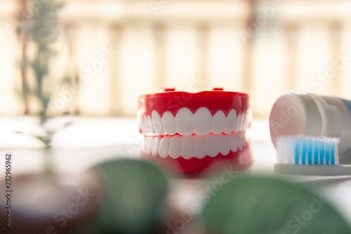Close up Denture with toothpaste Toothbrush on blurred background.Metaphor for oral, dentures jaw toothy healthcare protect.