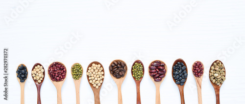 Assortment of beans in wooden spoon isolated on white background