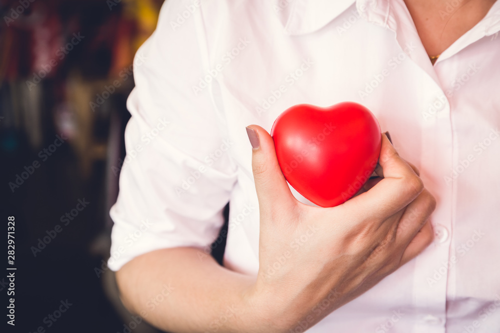 woman hold red heart and wearing white shirt woman hold red heart and wearing white shirt