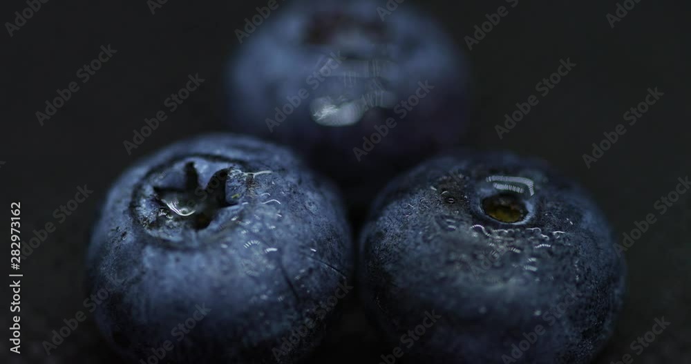 Close up macro shot of blueberries laying on dark splashed and spayed water background captured water drops in slow motion. Close up macro shot of blueberries laying on dark splashed and spayed water background captured water drops in slow motion.