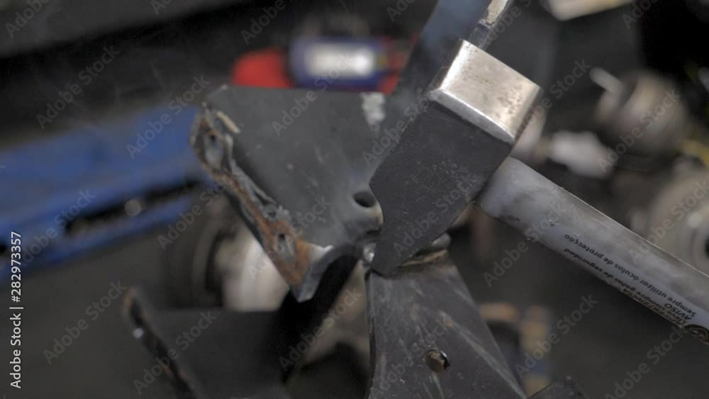 Knocking with a hammer in slow motion in a mechanic garage Knocking with a hammer in slow motion in a mechanic garage