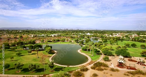 Aerial ascent from a desert playground and Granada park the Phoenix, Arizona skyline appears to the south. photo