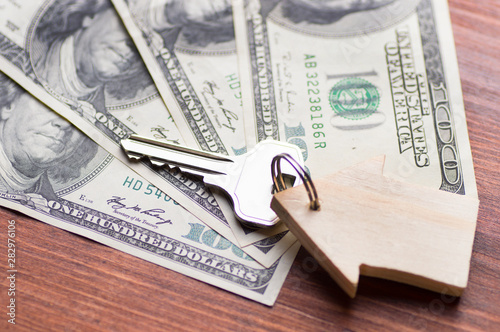 Valokuva Small Model wooden House and Keys on One Hundred Dollar Bills on wooden backgrou