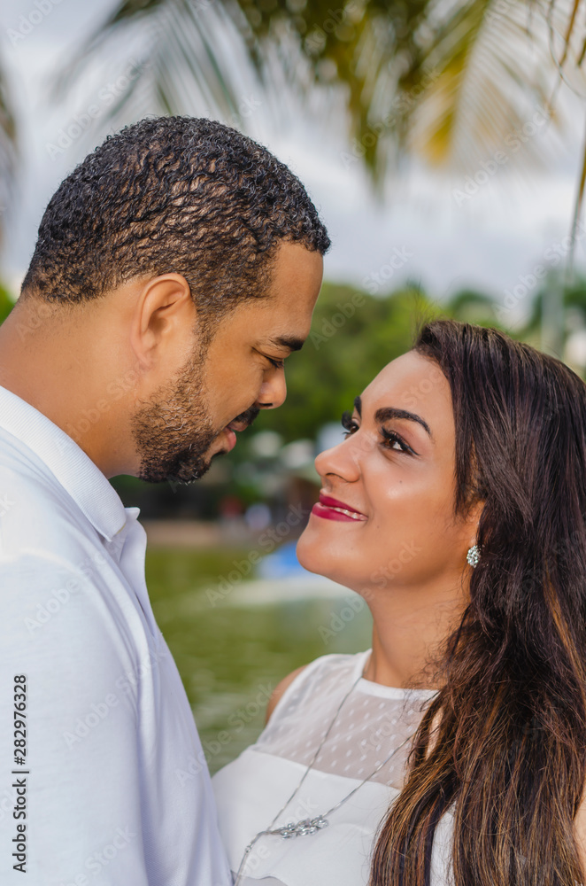 couple of young latin american men and women and happy in an outdoor portrait, together in a park, ju both romantically laughing and hugging couple of young latin american men and women and happy in an outdoor portrait, together in a park, ju both romantically laughing and hugging