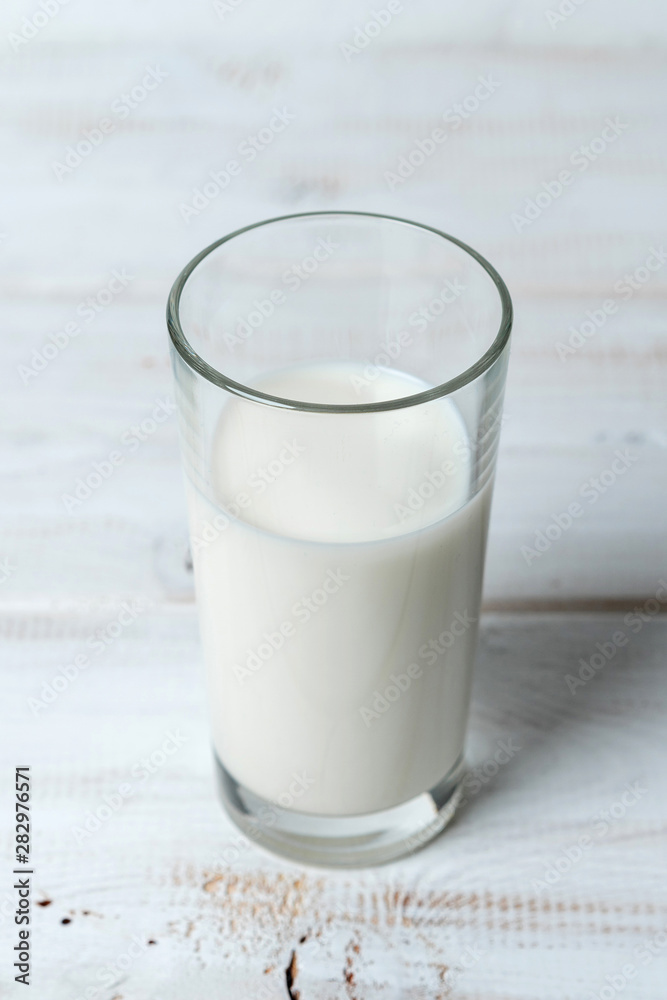 glass of milk on white wooden table glass of milk on white wooden table