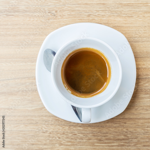 Black coffee in white cup on wooden background.