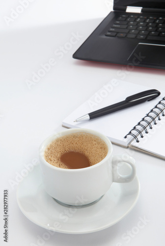 cup of coffee and pen on laptop