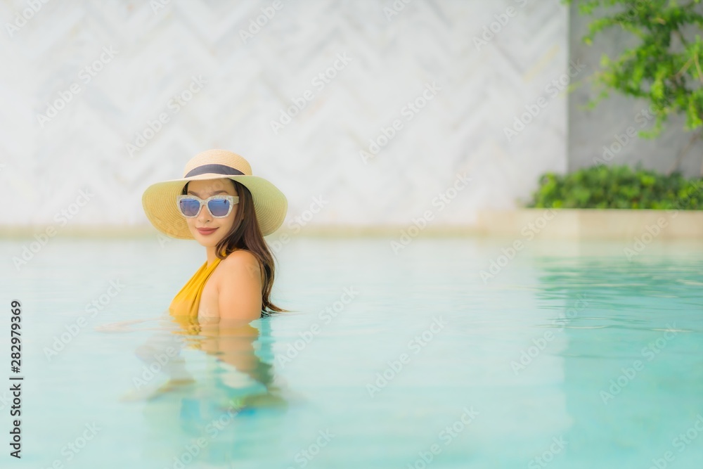 Portrait asian beautiful young woman happy smile relax around outdoor swimming pool in holiday vacation