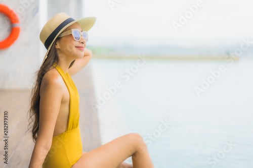 Portrait asian beautiful young woman happy smile relax around outdoor swimming pool in holiday vacation