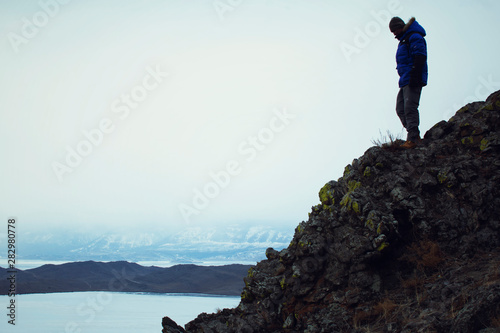 Happy man standing on top of mountain  man looking at landscape view