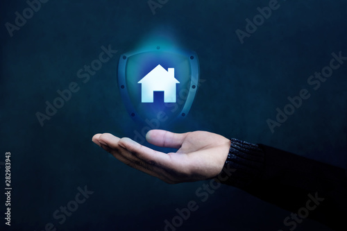 House or Family Insurance Concept. Company Supporting and Protecting their Customer by Shield, Home Icon floating over a Careful Gesture Hand of a Businessman
